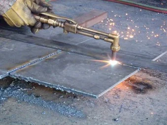 Trabajador realizando trabajos de oxicorte en placa de acero